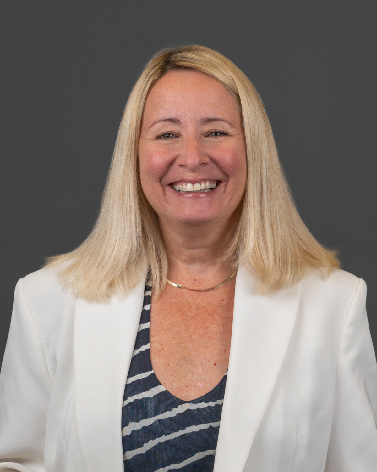 Barbara Brafman-Price, executive coach, smiling to camera in a white blazer